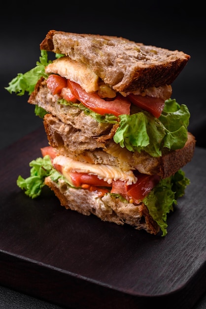 Sanduíche delicioso com tomates e alface crocantes da galinha do brinde