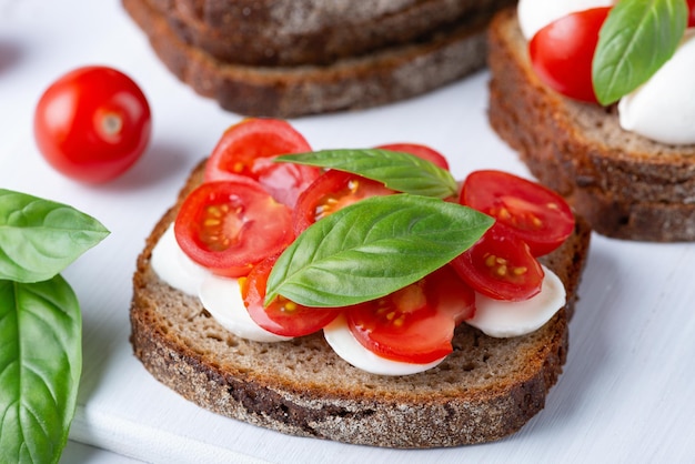 Sanduíche delicioso com tomates frescos da mussarela e manjericão