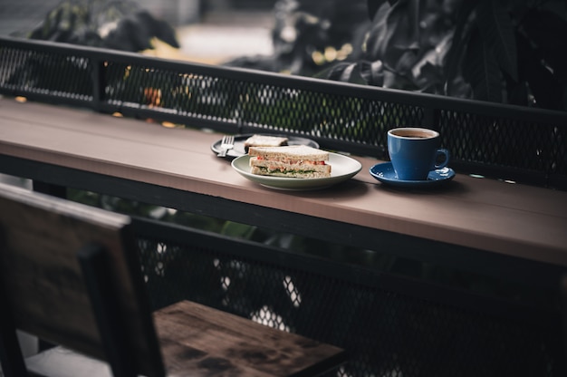 Foto sanduíche e café quente na barra de madeira