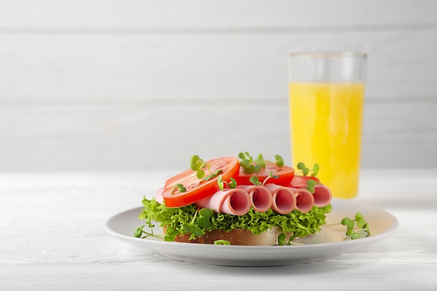 Sanduíche fresco com salsicha alface tomate e suco de laranja café da manhã europeu