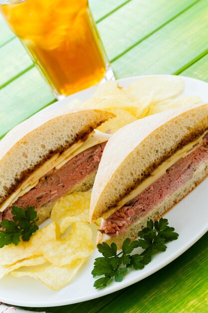 Sanduíche gourmet de rosbife com batatas fritas ao lado.