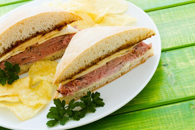 Sanduíche gourmet de rosbife com batatas fritas ao lado.