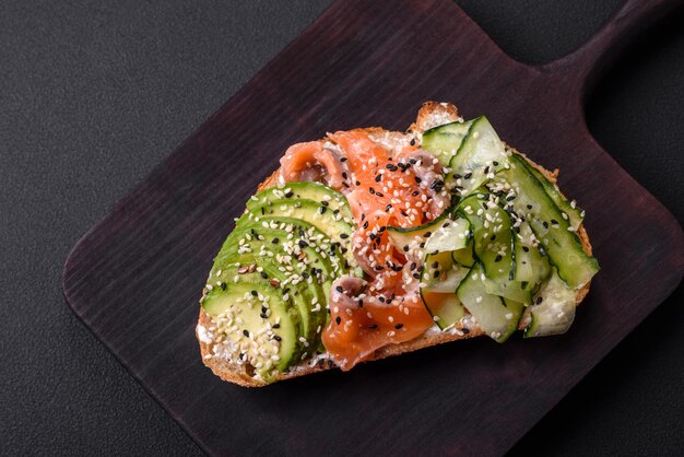 Sanduíche saboroso fresco com abacate de salmão e gergelim e sementes de linho