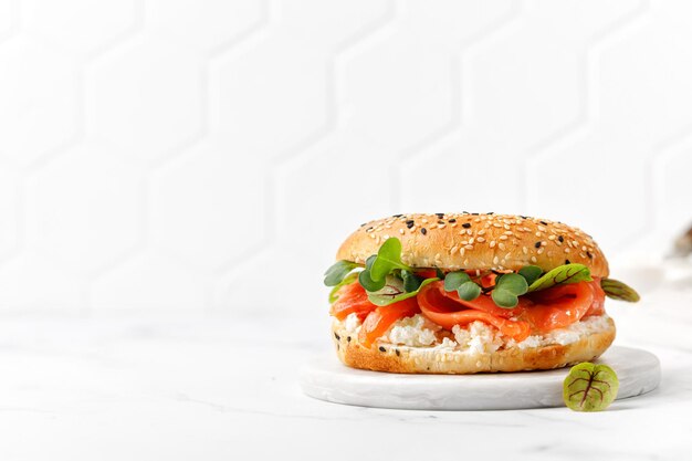 Sanduíche saudável de café da manhã Bagel com queijo creme de salmão e micro verdes a bordo Burger