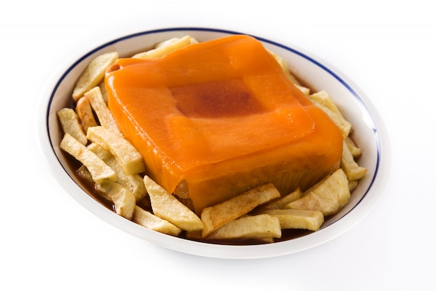 Sanduíche típico da francesinha portuguesa com batatas fritas, isolado na superfície branca