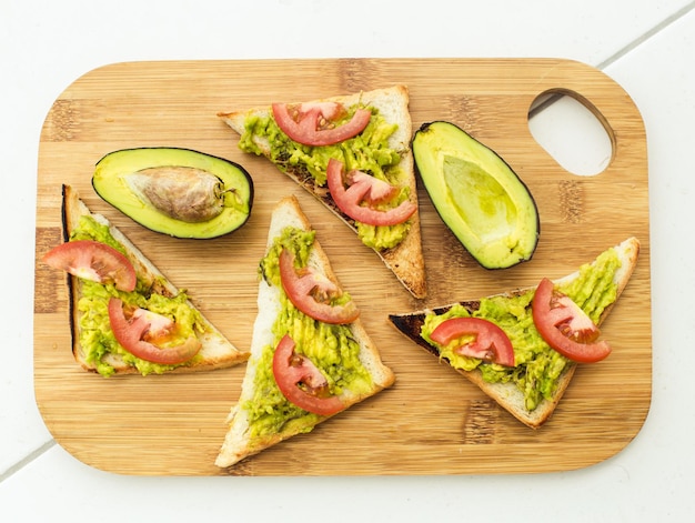 Foto sanduíche vegano com abacate e tomate na tábua