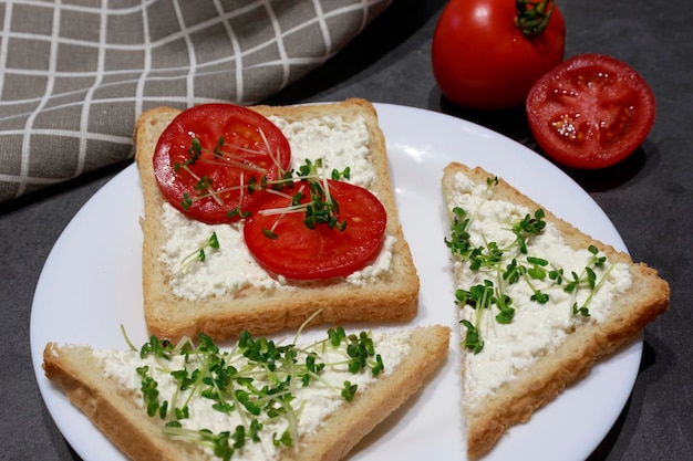 Sanduíches abertos vegetarianos com creme de queijo verde e tomate Delicioso aperitivo café da manhã ou lanche