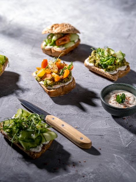 Sanduíches com abacate, pepino, cereja e queijo cottage em pão integral Um lanche saudável Molhos cremosos Restaurante servindo sanduíches