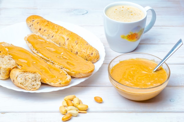 Sanduíches com creme de amendoim, uma xícara de bebida quente. Café da manhã.