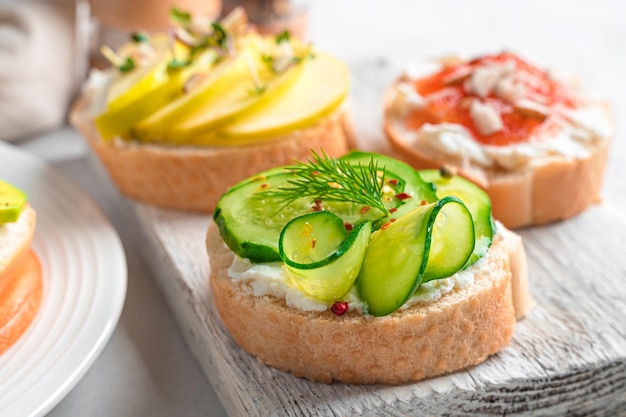 Sanduíches com maçã de pepino feta e geleia em um fundo claro Crostini Comida saudável