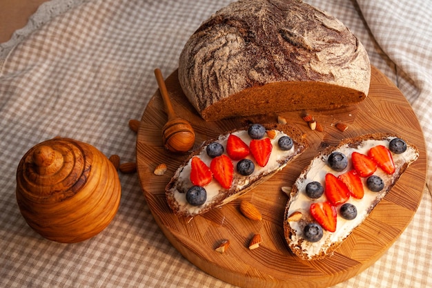 Sanduíches com pão de centeio caseiro, mel, queijo e frutas vermelhas