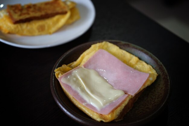 Foto sanduíches com presunto de ovo e queijo torrado fritos em prato