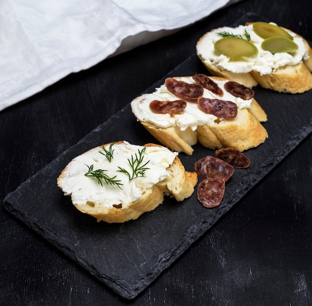 Sanduíches com queijo branco cremoso, salsicha, azeitonas e endro