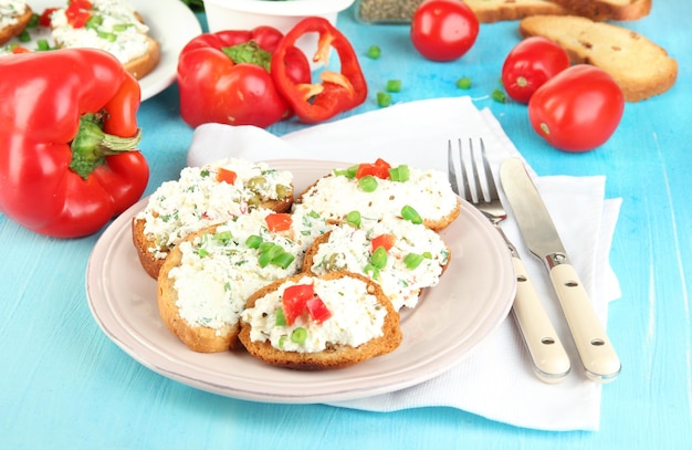 Sanduíches com queijo cottage e verduras em prato em uma mesa de madeira em close-up