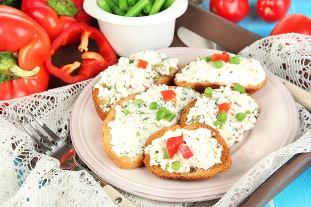 Sanduíches com queijo cottage e verduras no prato na mesa de madeira closeup