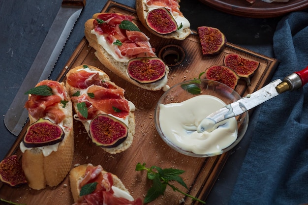 Sanduíches com queijo creme e jamon, aperitivos espanhóis de close-up com vinho