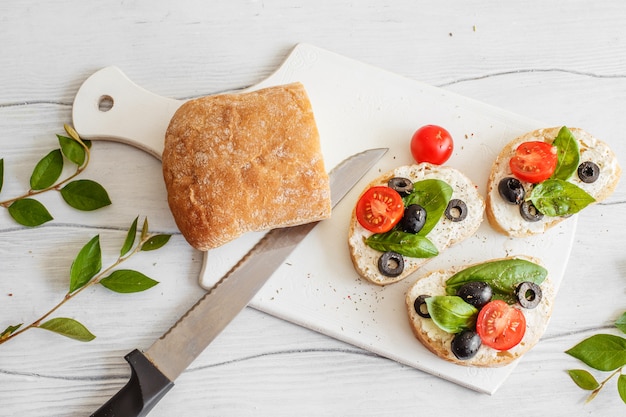 Sanduíches com tomates, azeitonas e manjericão