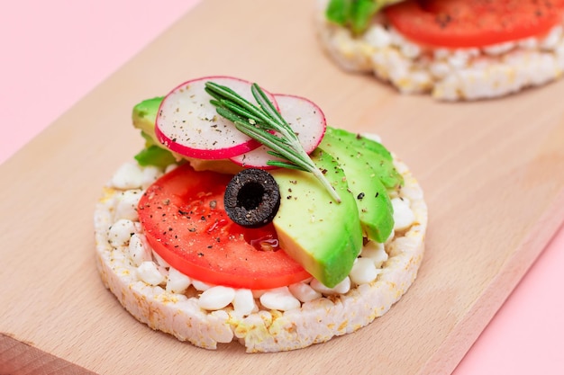 Sanduíches de bolo de arroz com azeitonas e rabanete do requeijão do tomate do abacate