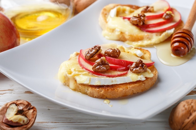 Sanduíches de bruschetta com queijo brie ou camembert, maçãs, nozes e mel