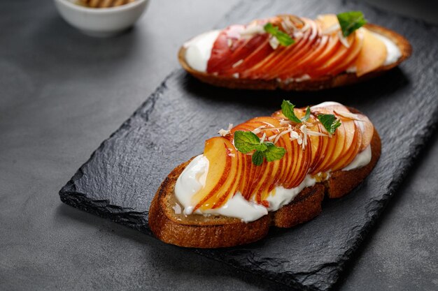 Sanduíches de bruschetta de lanche de torrada com cream cheese e pêssego nectarina Sanduíche de frutas saudáveis