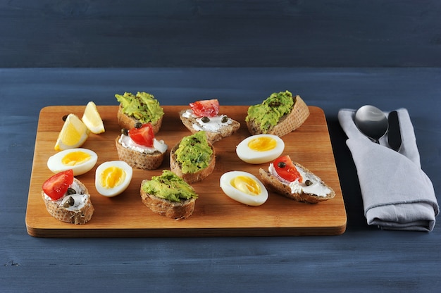 Sanduíches de canapé em uma placa de madeira