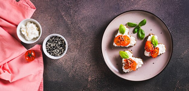 Foto sanduíches de coração com ricotta e tomates em pão de centeio em um prato