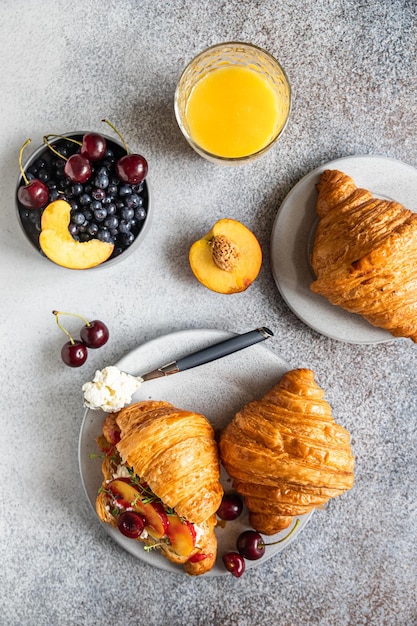 Sanduíches de croissant com nectarina de cereja e ricota com suco de laranja no saboroso café da manhã