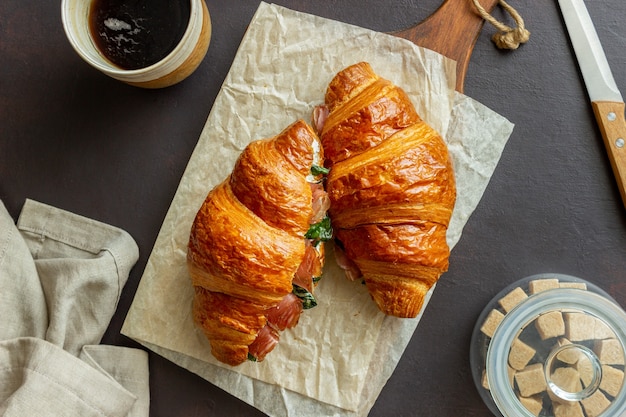 Sanduíches de croissants com presunto, manjericão e queijo branco. cozinha francesa. café da manhã.