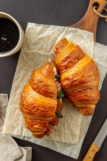 Sanduíches de croissants com presunto, manjericão e queijo branco. Cozinha francesa. Café da manhã.