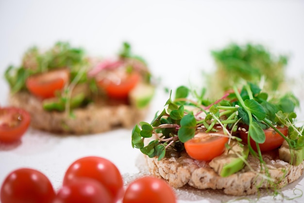 Sanduíches de lanches veganos de tomate e abacate com microgreen de tomate e espinafre