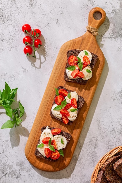 Sanduíches de pão integral com queijo tomate e manjericão deixa vista superior Conceito de lanche saudável