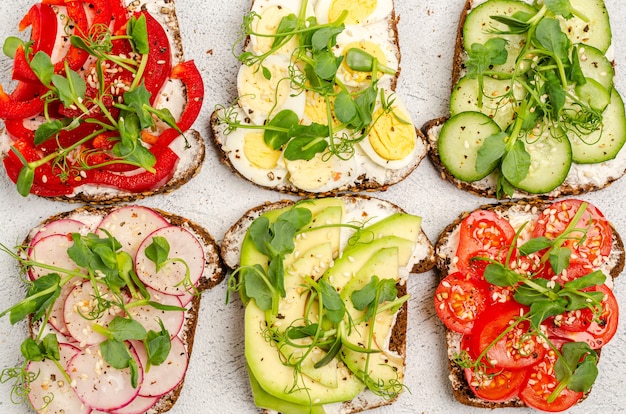 Sanduíches diferentes com vegetais e microgreens na torrada