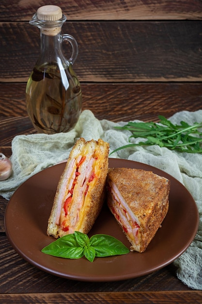 Sanduíches fritos em migalhas de pão com queijo de presunto e tomates