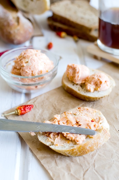 Sanduíches no café da manhã com manteiga caseira com especiarias e tomates, pimenta e temperos