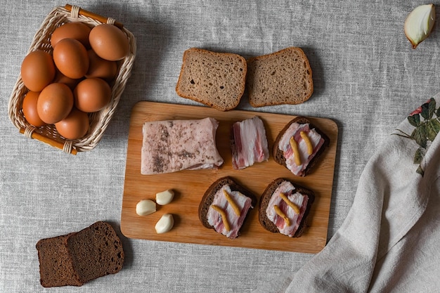 Foto sanduíches prontos de comida natural rústica de banha de pão de centeio preto com mostarda e ovos cozidos