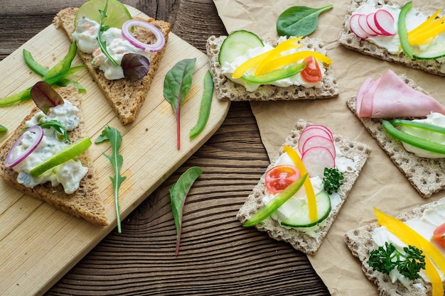 Sanduíches saudáveis com legumes frescos Torradas de café da manhã na tábua de madeira Café da manhã equilibrado