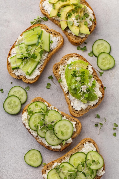 Sanduíches verdes vegetarianos com abacate e pepino com microgreens em um fundo claro