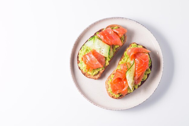 Sándwich abierto con salmón ahumado y salado para un desayuno saludable. Trucha y aguacate sobre bruschetta t