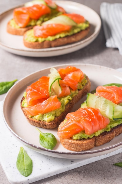 Sándwich abierto con salmón ahumado y salado para un desayuno saludable. Trucha y aguacate sobre bruschetta t