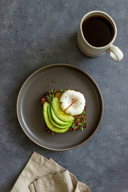 Sandwich con aguacate y huevo escalfado. Alimentación saludable Comida vegetariana. Desayuno.