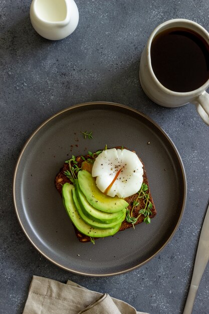 Sandwich con aguacate y huevo escalfado. Alimentación saludable Comida vegetariana. Desayuno.