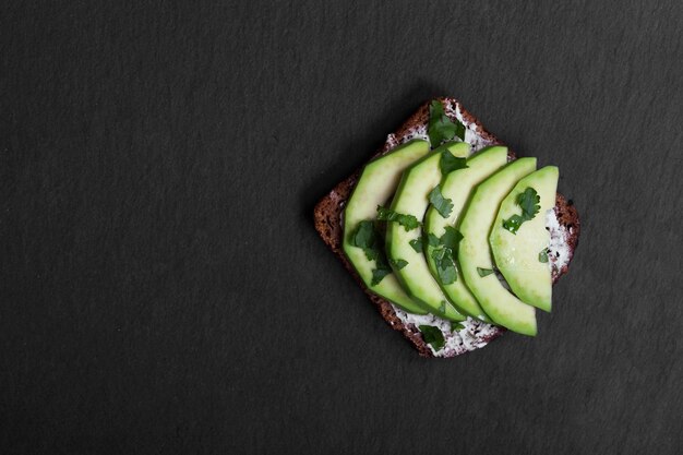 Sándwich de aguacate en pan de centeno oscuro hecho con aguacates frescos en rodajas desde arriba