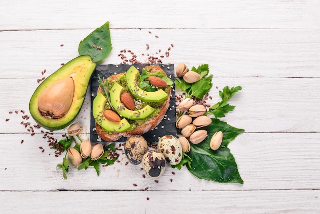 Sándwich con aguacates y almendras Sobre un fondo de madera Vista superior Espacio libre para el texto