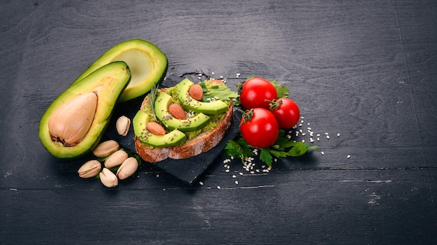 Sándwich con aguacates y almendras Sobre un fondo de madera Vista superior Espacio libre para el texto