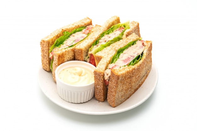 Sandwich de atún casero sobre fondo blanco.