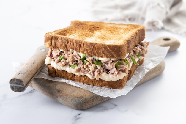 Sándwich de atún con verduras sobre fondo de mármol