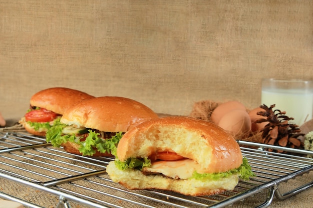 Sandwich auf dem Grill mit Scheiben frischer Tomaten, Schinken, Käse und Salat