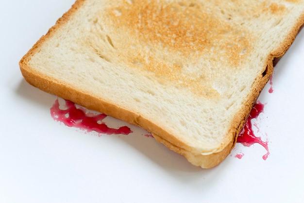 Sandwich auf den Kopf gestellt mit Marmelade spritzt auf weiß