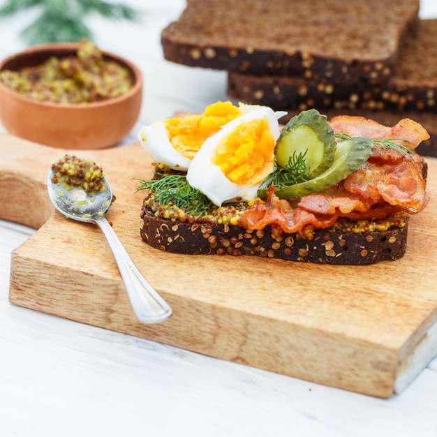 Sandwich aus Roggenbrot mit Koriander mit gebratenem Speck