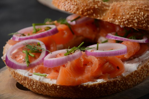 Sándwich de bagel con salmón, queso crema, pepino y cebolla